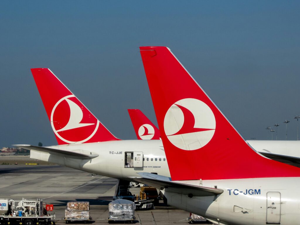 Red-tailed Turkish Airlines planes on the tarmac at Istanbul Airport, showcasing travel and aviation.
