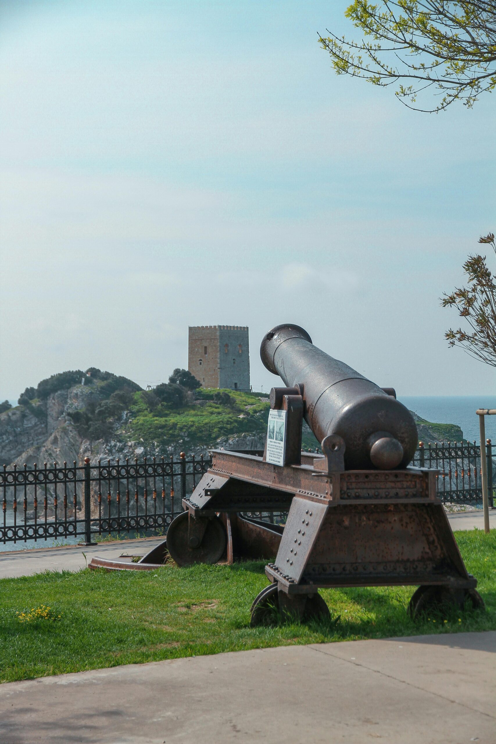A vintage cannon in Şile, İstanbul offering a view to a historic castle by the sea, embodying Turkish heritage.