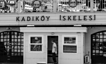 Black and white photo of Kadıköy Pier, Istanbul, showcasing urban life in Turkey.
