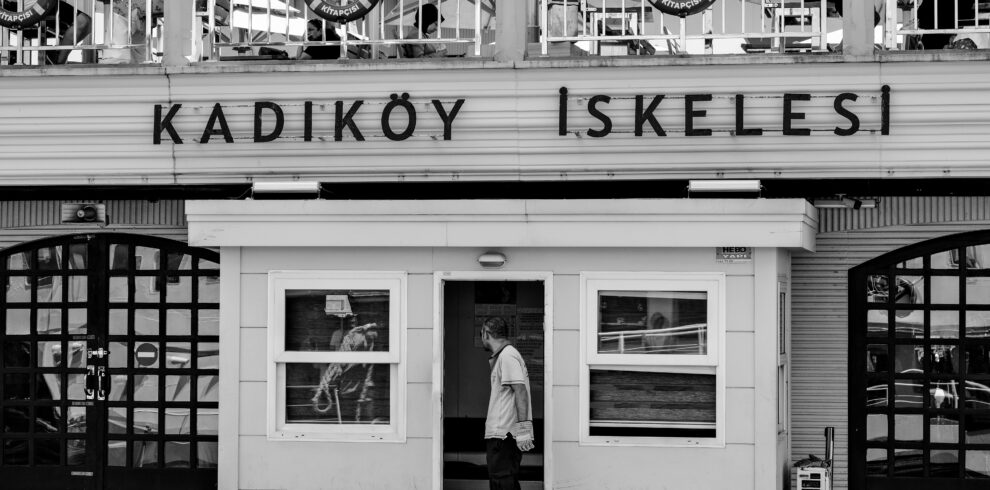 Black and white photo of Kadıköy Pier, Istanbul, showcasing urban life in Turkey.