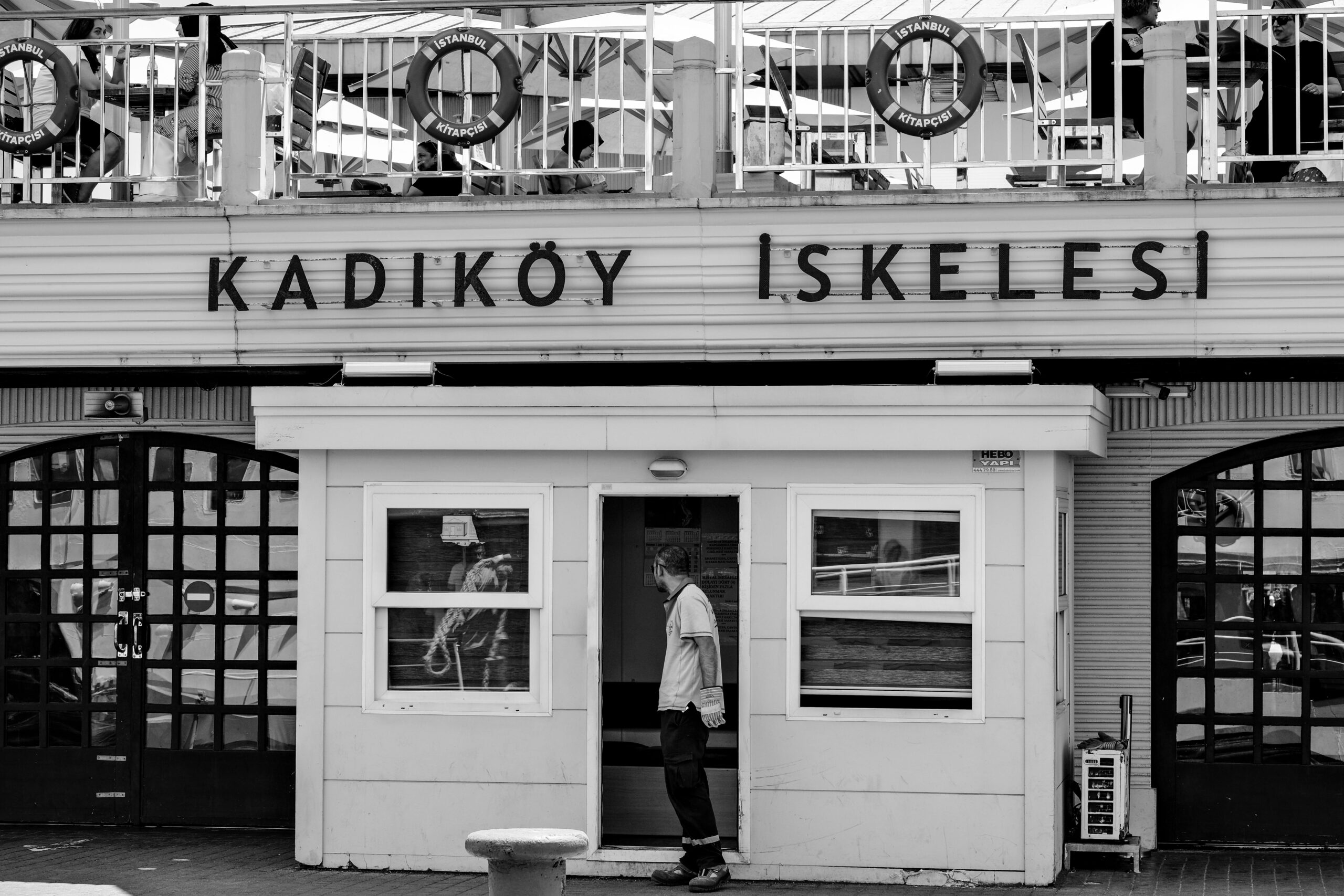 Black and white photo of Kadıköy Pier, Istanbul, showcasing urban life in Turkey.