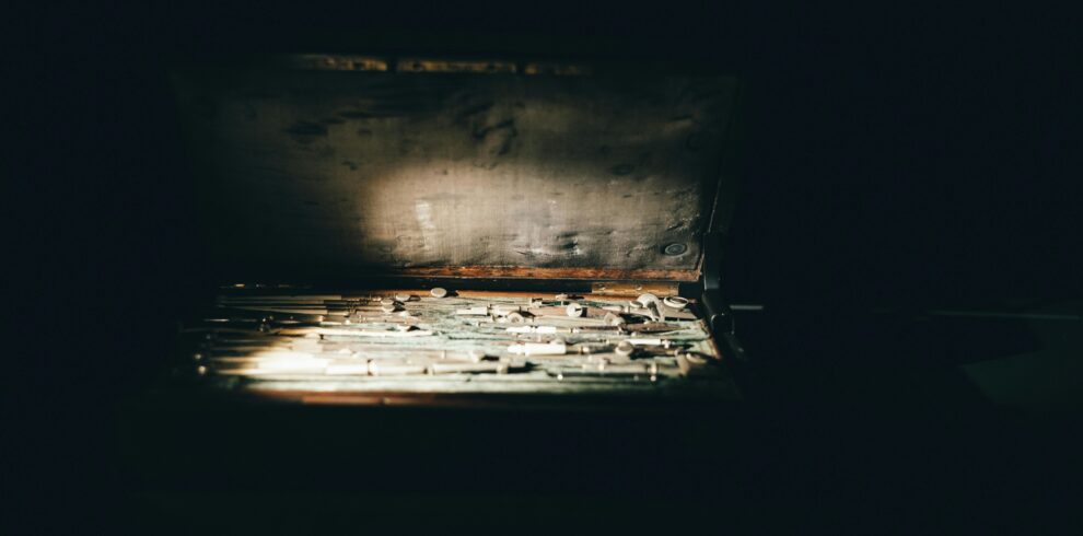 A vintage toolbox with various tools illuminated by sunlight. Captured indoors in Türkiye.