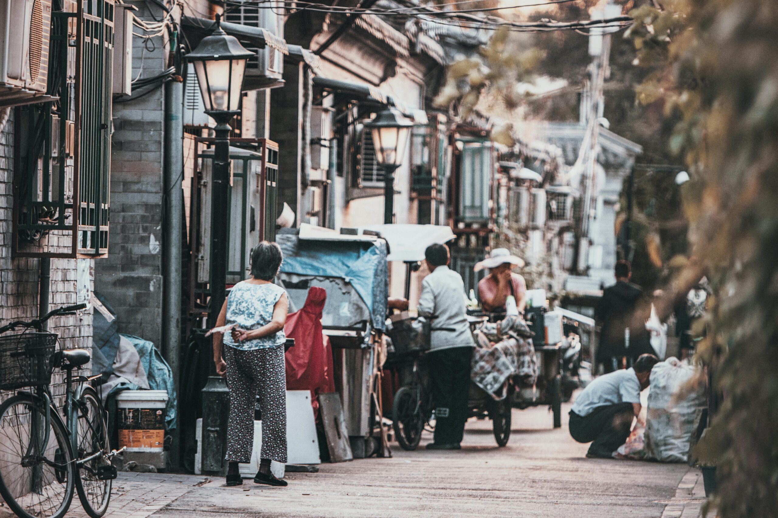 A glimpse into the vibrant street life of a traditional hutong in Beijing, China, showcasing daily interactions.