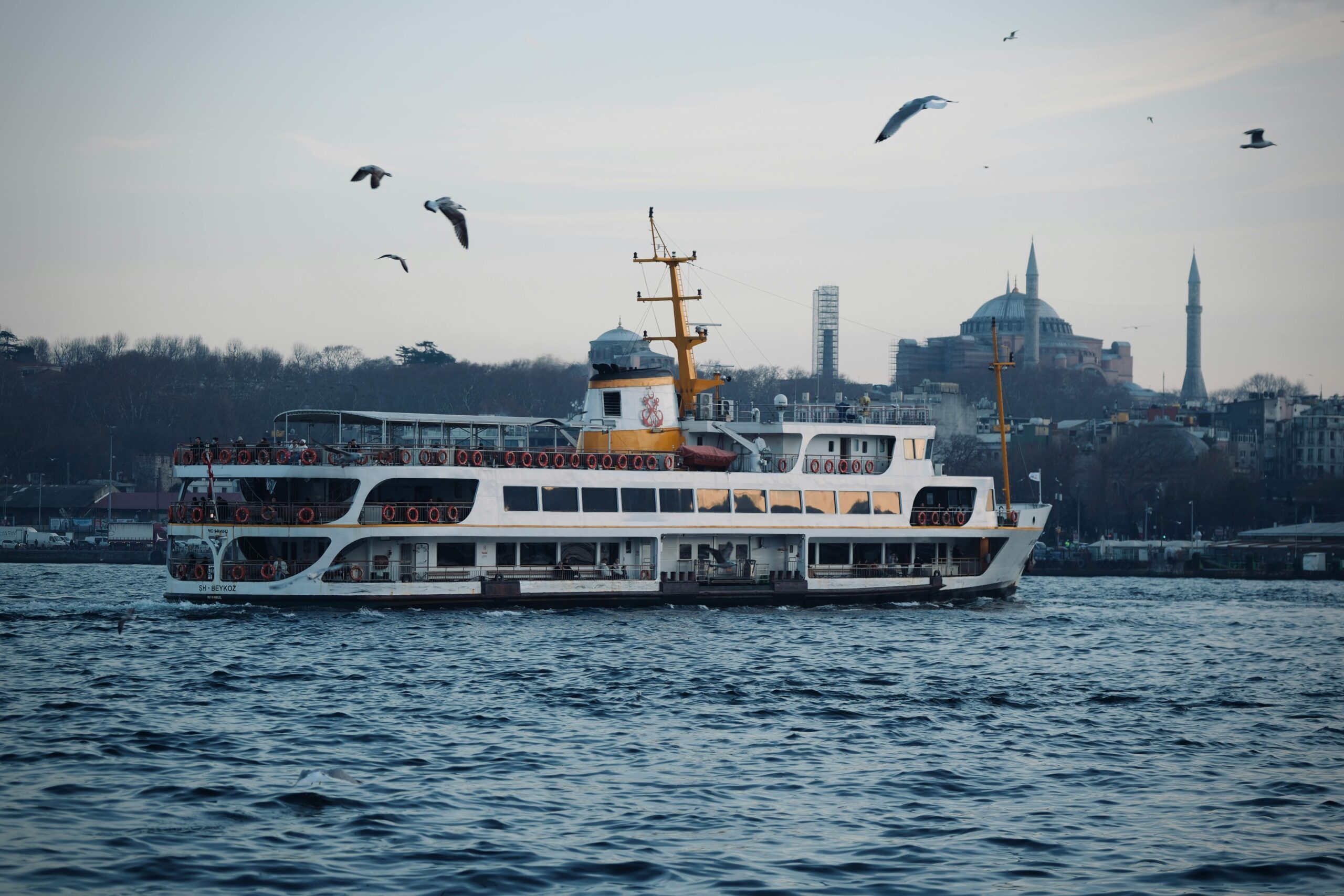 A ferry sails on the Bosphorus with the iconic Hagia Sophia in İstanbul, Türkiye.