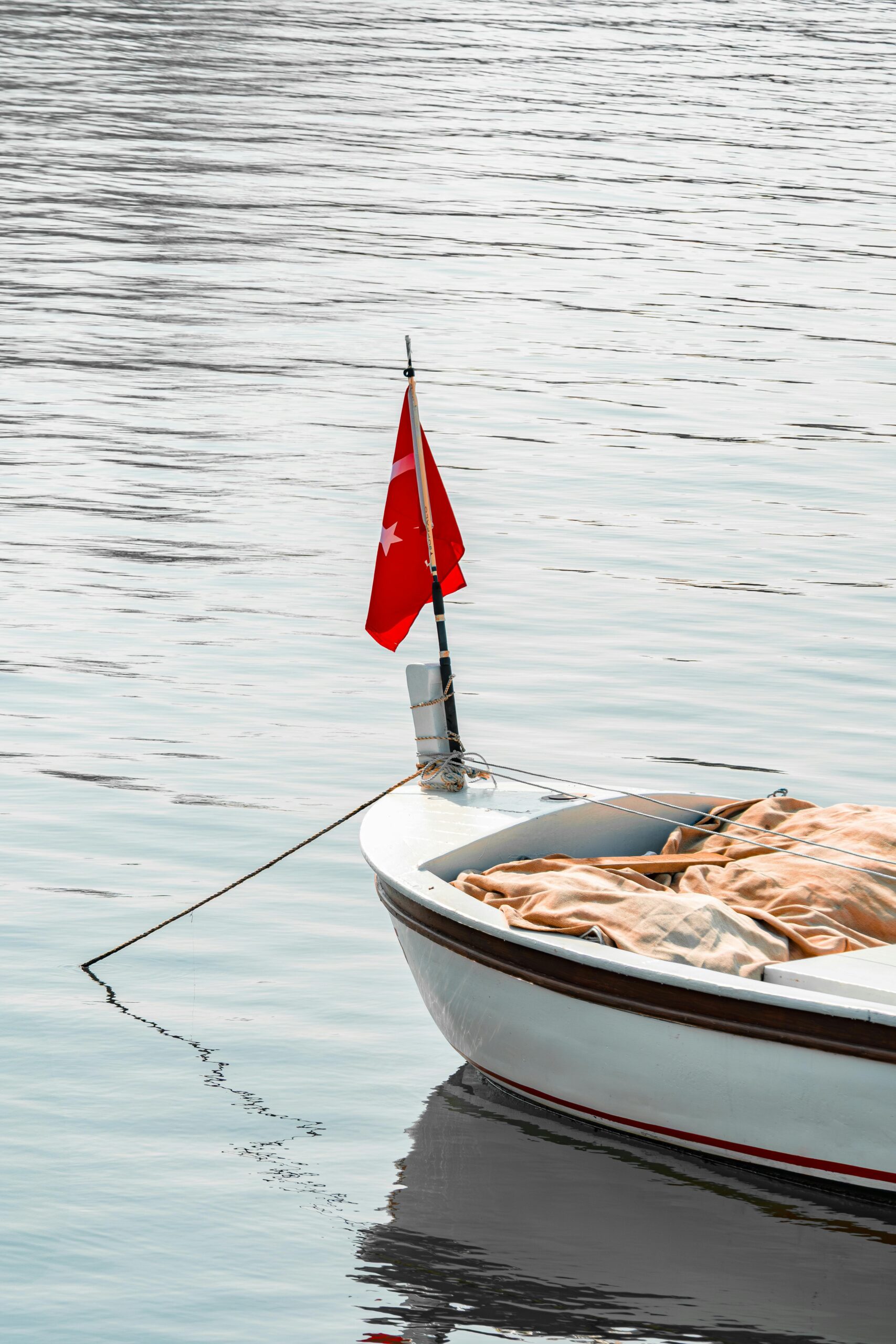 A peaceful boat with a Turkish flag floating on calm waters in Yalova, Türkiye.